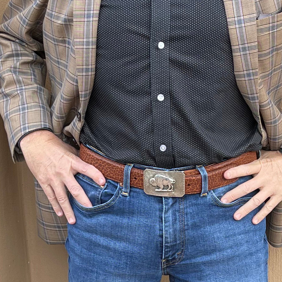 Waist view of man wearing Mesa Bison belt buckle.