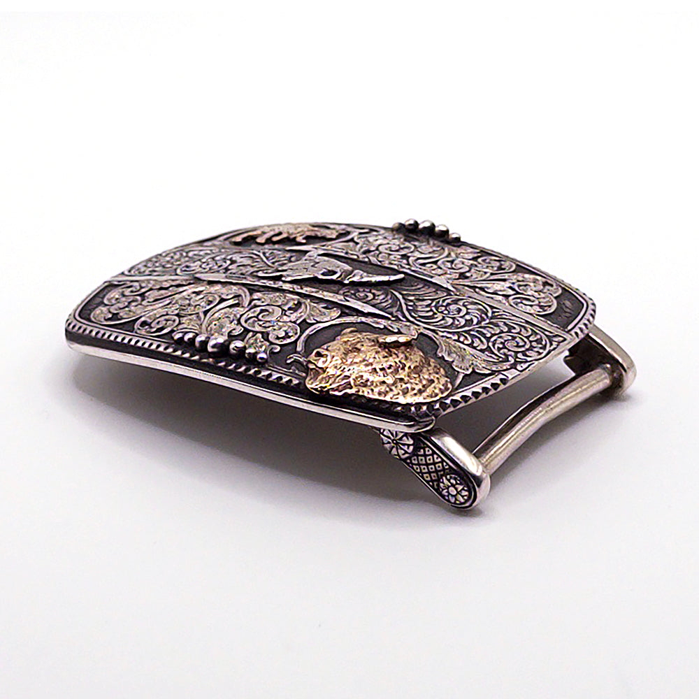 Decorative belt buckle with intricate designs on a white background