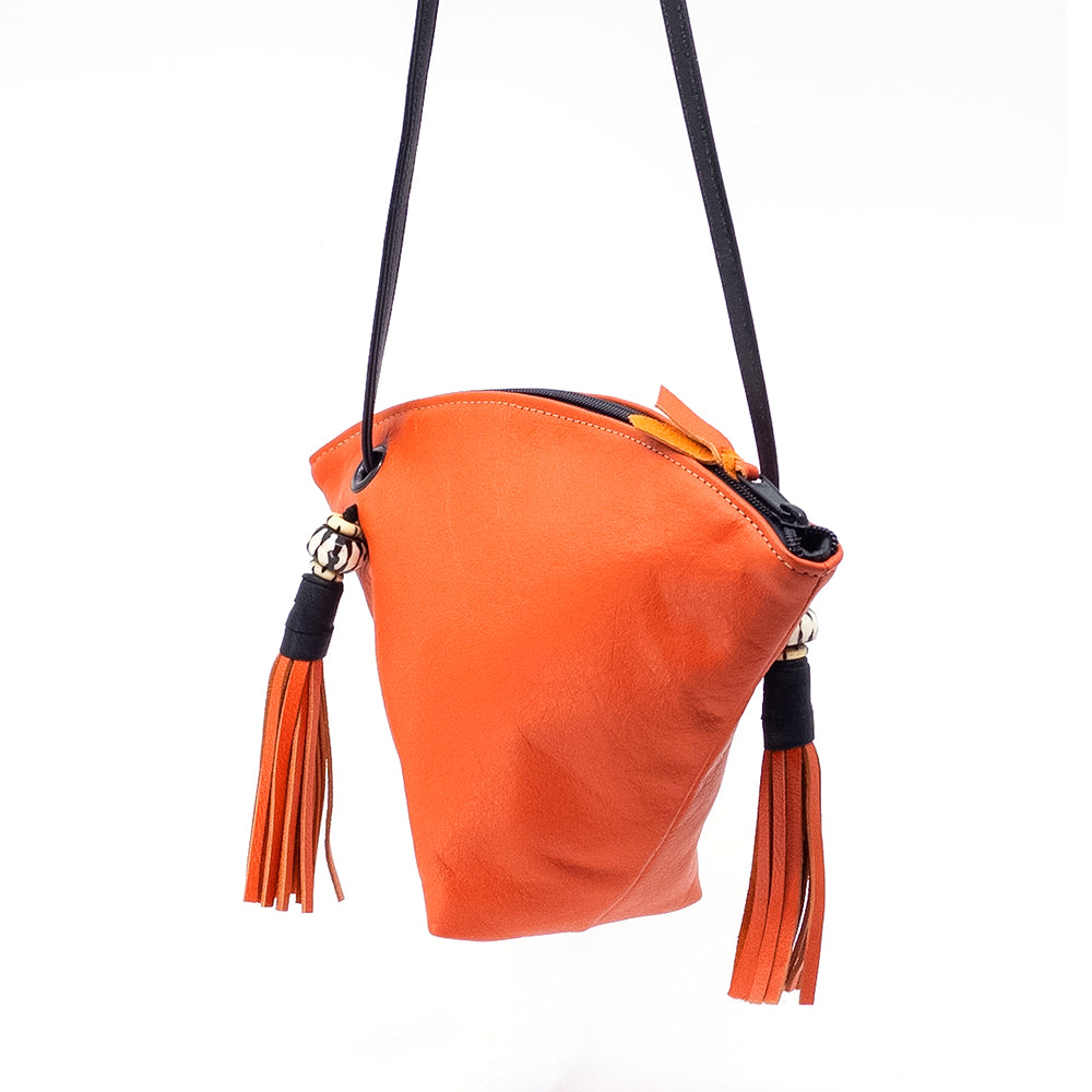 Sideview of the orange leather Fortune Cookie crossbody bag.