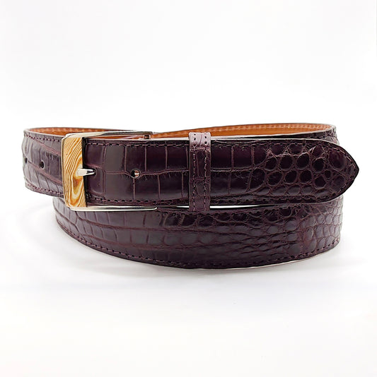 Neil Hunt Mokume-Gane buckle shown on a burgundy Nile crocodile belt strap.