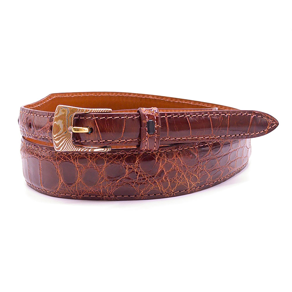 Neil Hunt Sydney Mokume-Gane belt buckle shown on a cognac alligator belt strap.